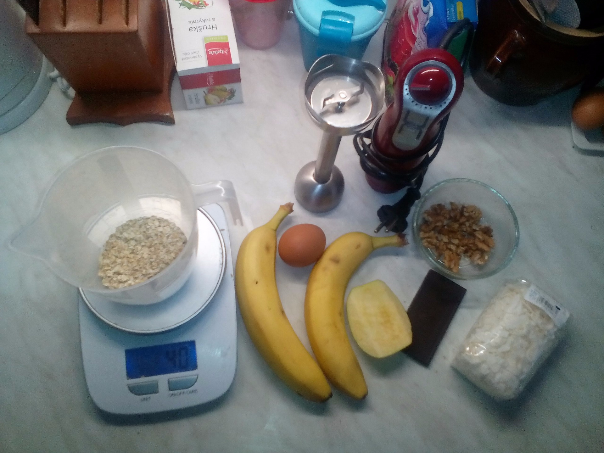 Potřebujeme: Banán, vejce, vločky, hořká čokoláda, kokos, jablko(a nebo jiné ovoce), ořechy, tyčový mixér+nádobu ve které budeme budeme mixovat těsto